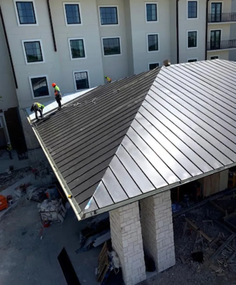 Crew installing standing seam metal roof panels on a commercial project in Uniontown